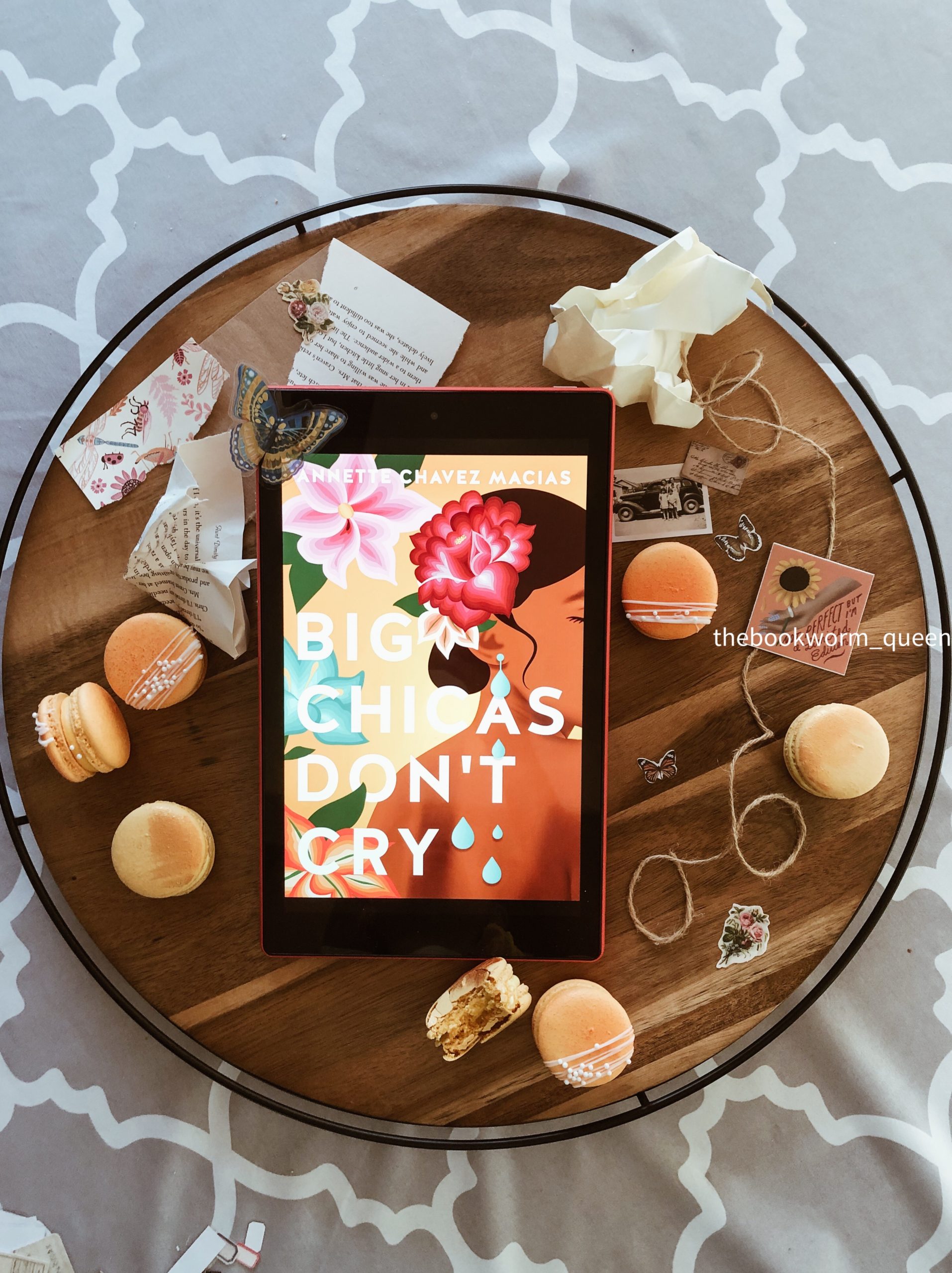 A circle tray that carries the book, Big Chicas Dont Cry, surrounded by macarons and scrapbook items.